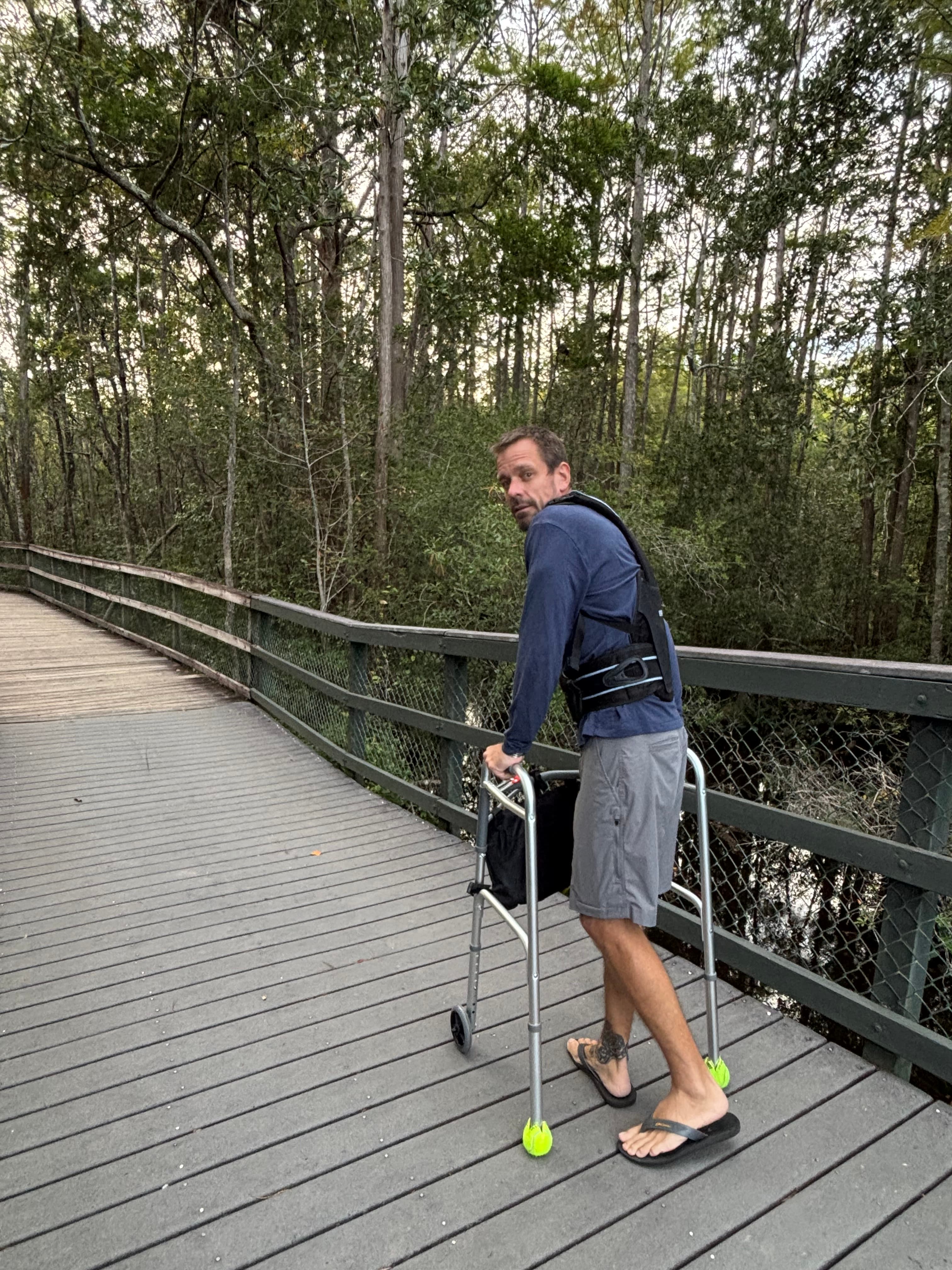 Michael Cavett walking on a boardwalk with a walker