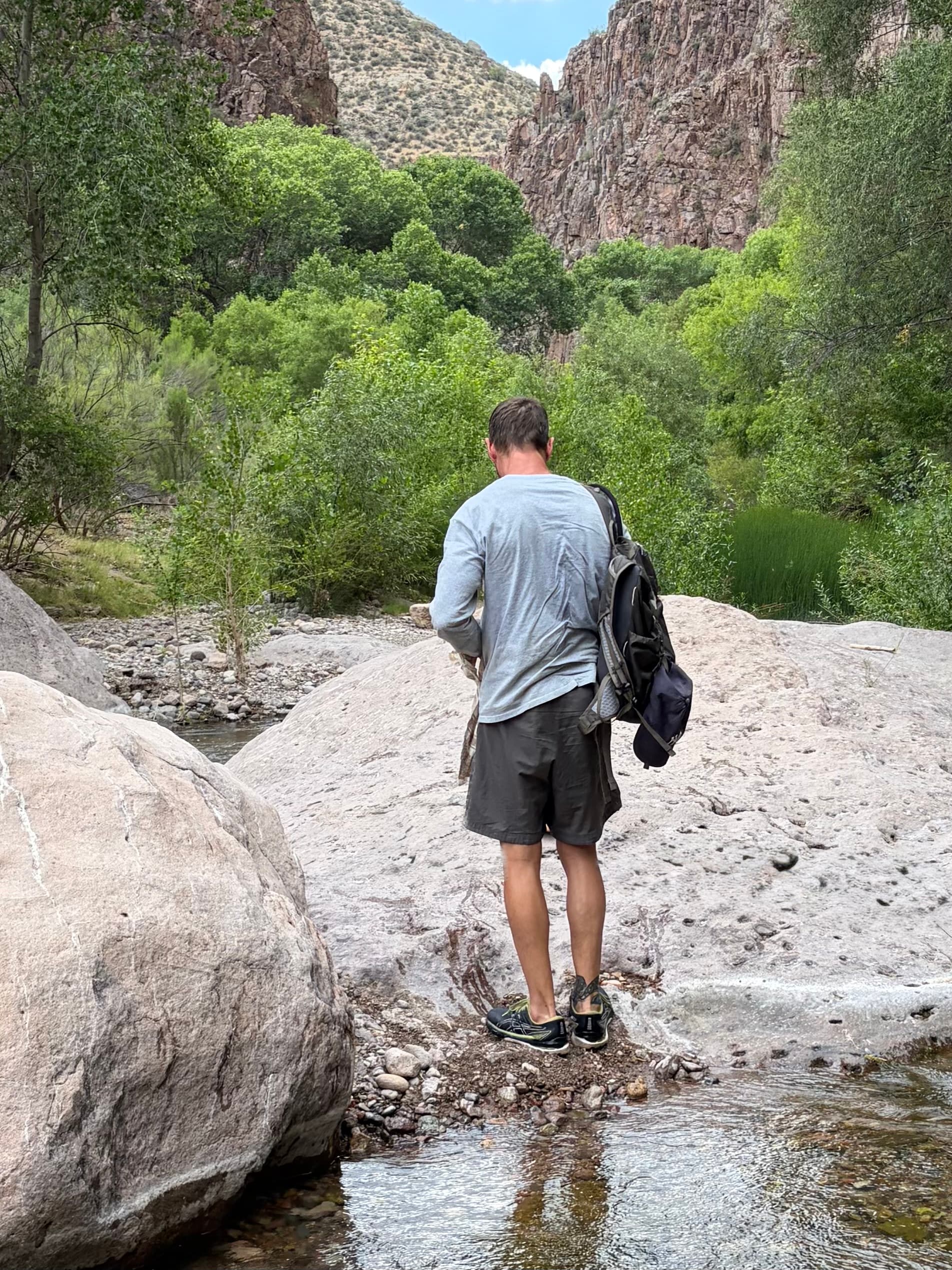 Michael Cavett standing on rocks at the edge of a creek in a canyon